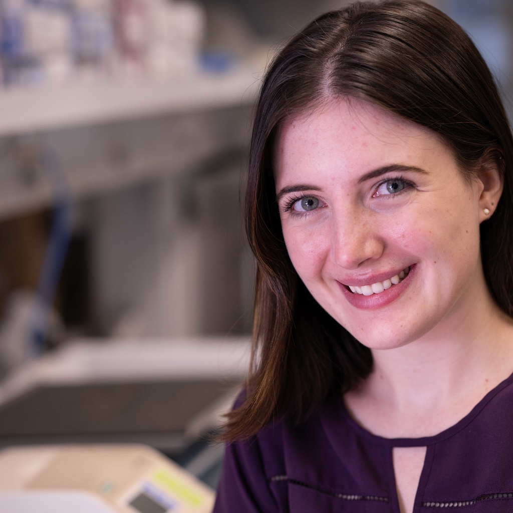 Young, white woman in her lab smiling into the camera.
