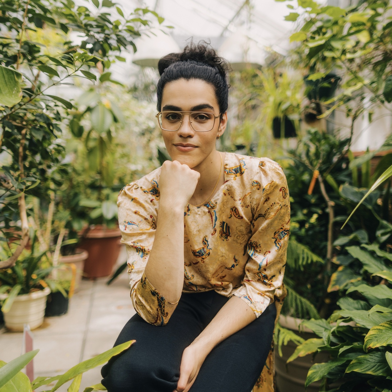 Paras Bassuk seated in a lush green house